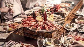 Un plateau de fruits de mer comprenant différents types de crustacés et une tranche de citron, posé sur une table.