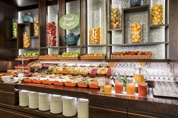 A buffet with various fruits, vegetables, and beverages. - Grand Elysee Hamburg (Hamburg)