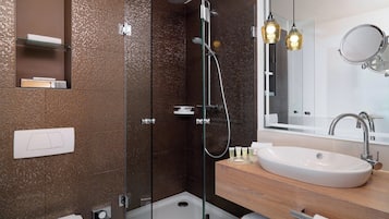 Ein modernes Badezimmer mit einer Duschkabine aus Glas, einem weißen Waschbecken und einem Holz-Badmöbel.