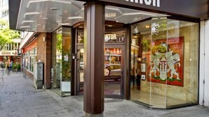 L’entrée d’un hôtel, avec une enseigne indiquant « HÔTEL SENATOR » et une façade en verre.