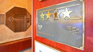 Une plaque en bois affichant une évaluation par étoiles et les différentes catégories de chambres.