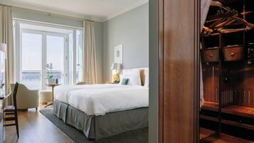 Habitación de hotel con una cama grande, un escritorio, una silla, un armario y vistas al exterior.