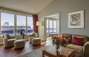 Enjoy a waterfront view from the large window, unwind in the cozy seating area, and relax with a vase of flowers.