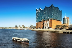 Ein Fluss mit einem Boot und einem modernen Gebäude mit außergewöhnlicher Architektur.