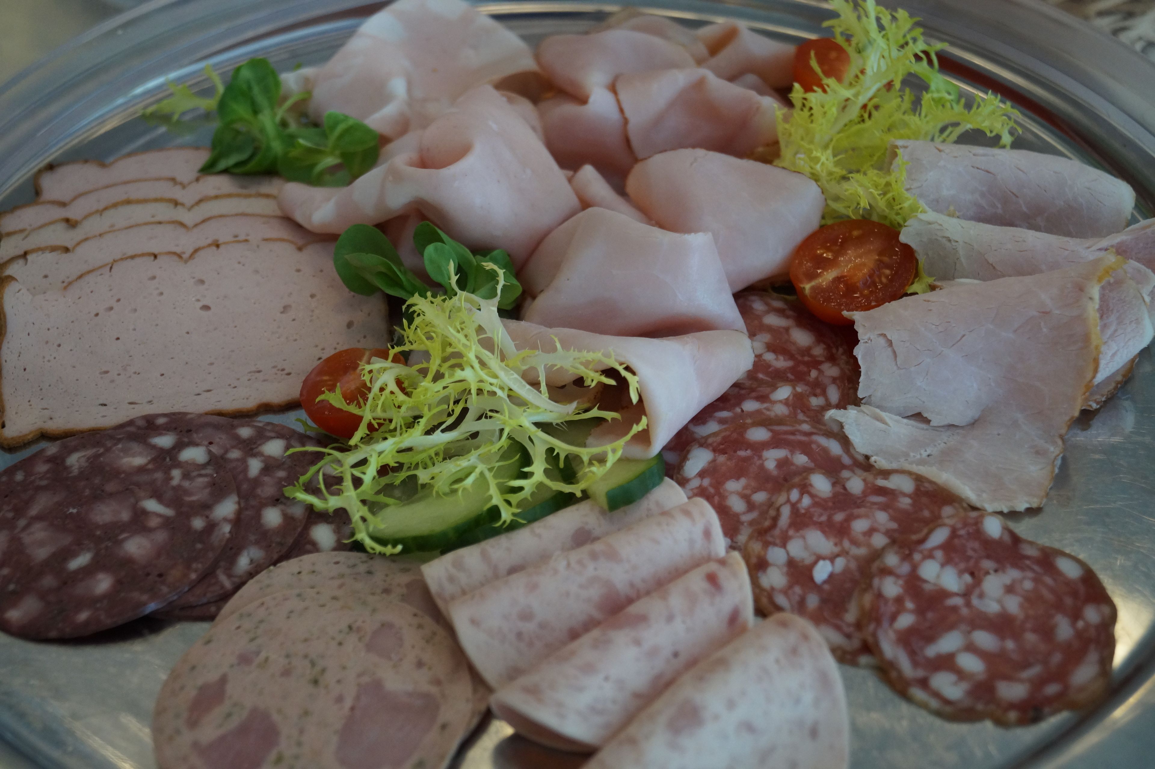 Eine Auswahl an geschnittenem Fleisch und Gemüse auf einer Platte.
