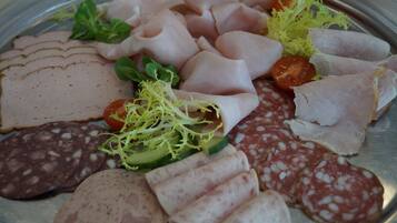Eine Auswahl an geschnittenem Fleisch und Gemüse auf einer Platte.
