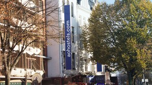 A building with a prominent vertical sign reading "aohotels.com".