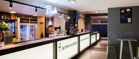 Eine Bar mit einer Neonreklame, einer Speisekarte und einer Theke.