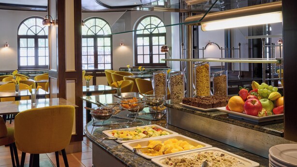 A buffet with various food options, including fruits, vegetables, and desserts. - Leonardo Hotel & Residenz München (Munich)