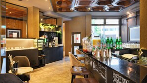 Un café moderne doté d’un bar, de coins salon et offrant une vue sur l’extérieur.