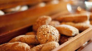 A variety of breads and pastries in wooden trays.