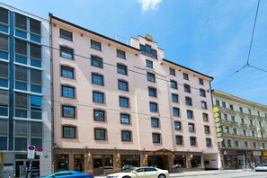 A multi-story hotel with a classic architectural style, featuring a prominent entrance and a series of windows.