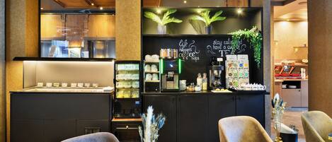 Una cafetería moderna con mostrador, zona de asientos y una máquina de café.