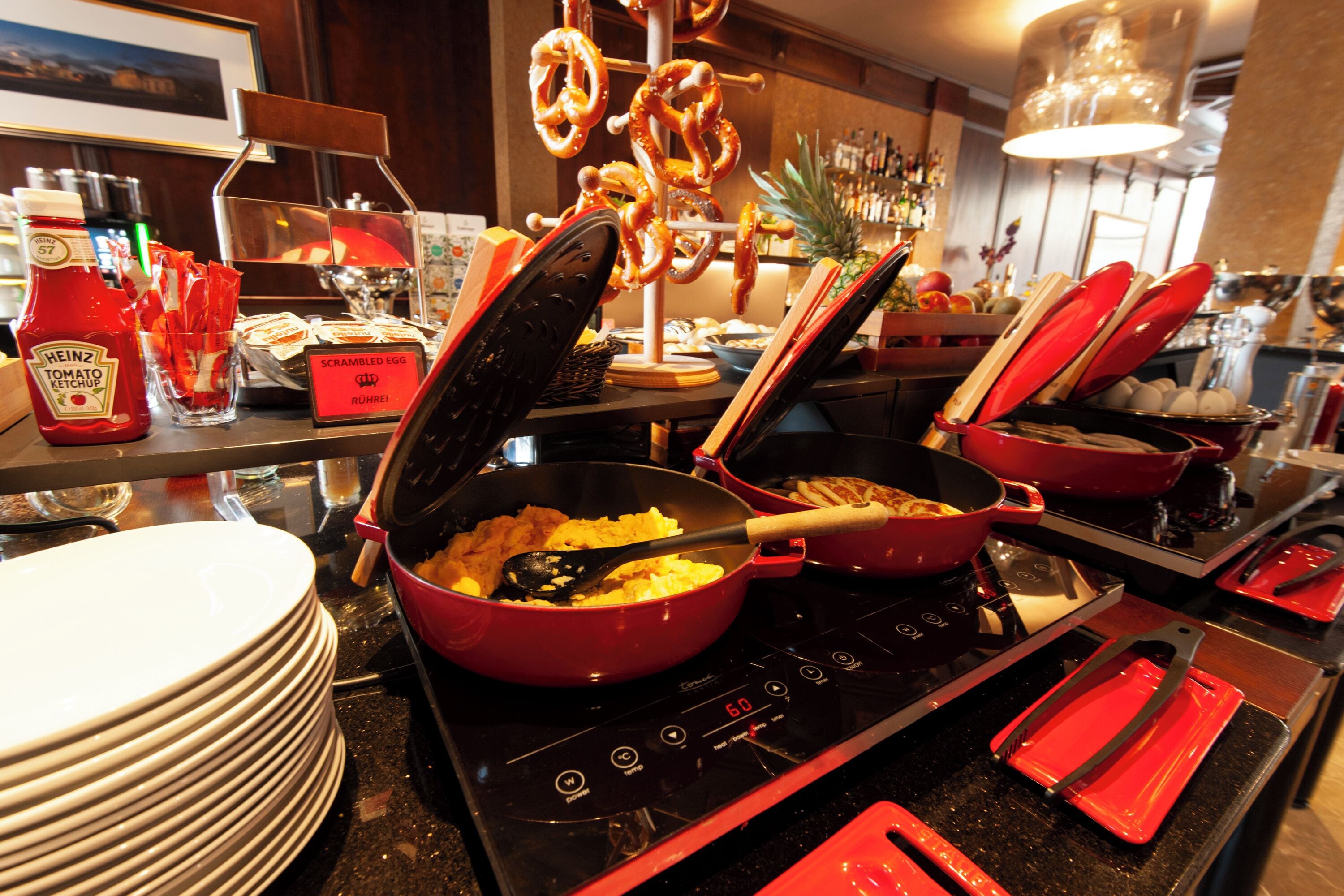 A kitchen with a stove, pots, and a variety of condiments.