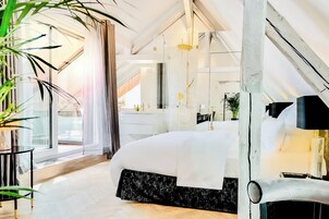 Una camera da letto moderna con un letto grande, una toeletta e un'ampia finestra con tende.