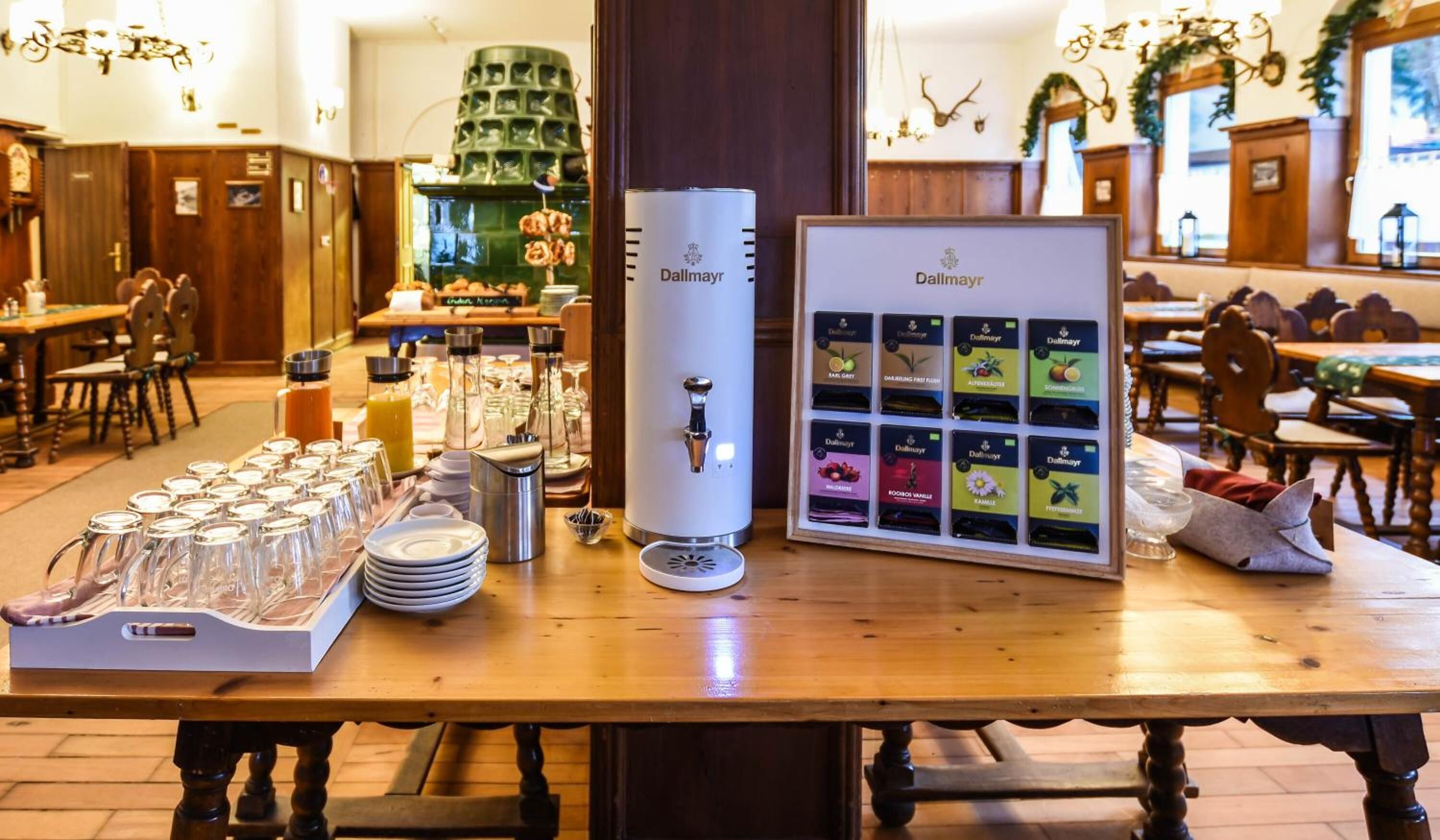 Una barra de desayuno con una cafetera, cristalería y una variedad de productos alimenticios envasados.