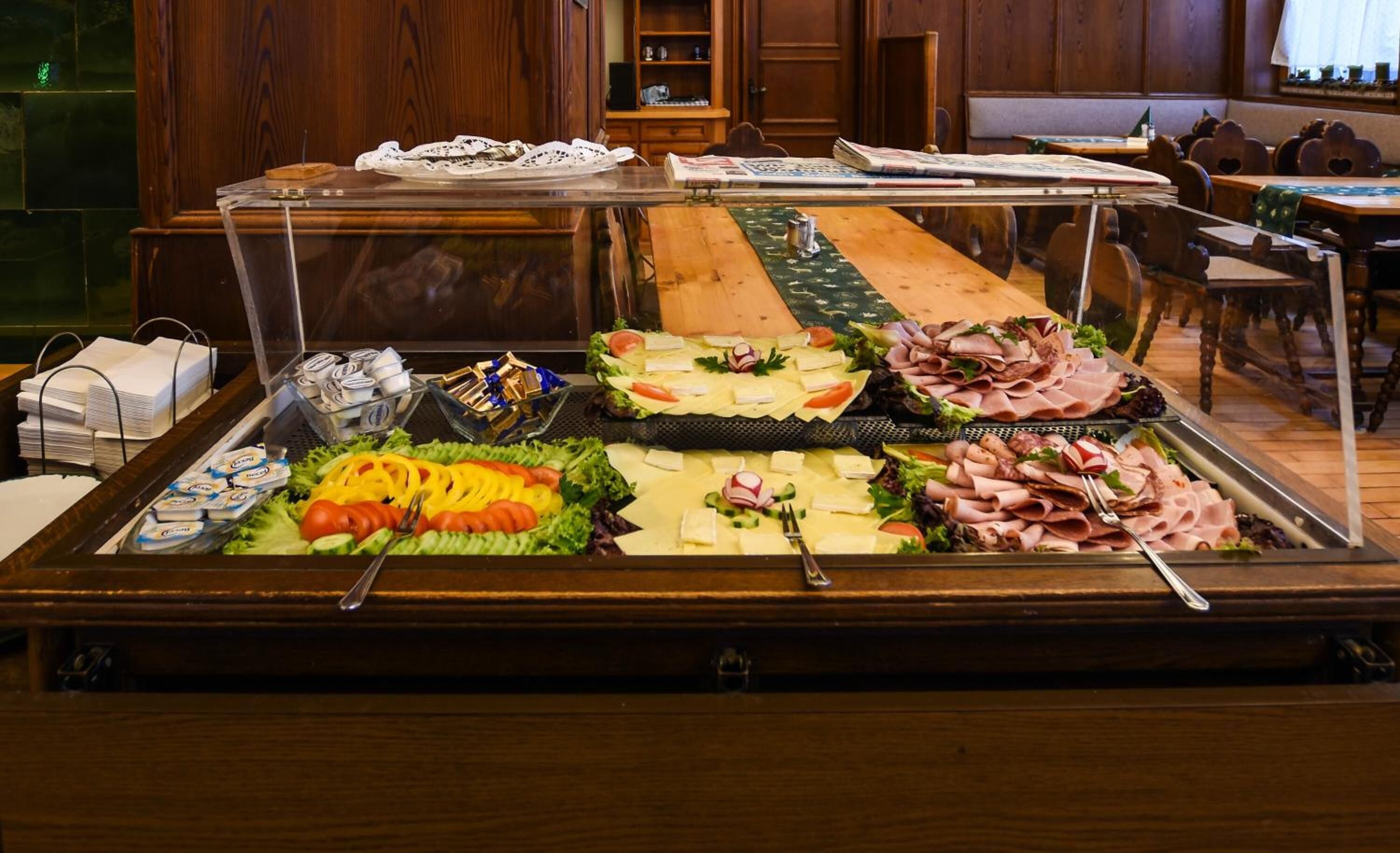 A buffet with various food items including salads, cheeses, and meats.