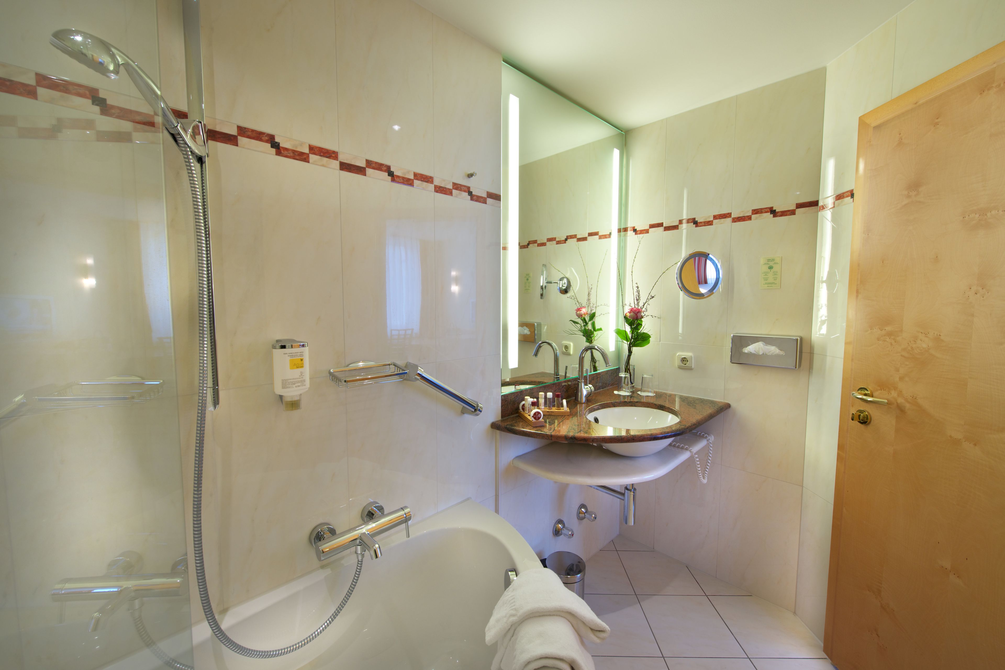 A bathroom with a bathtub, a sink, a mirror, and a shower.