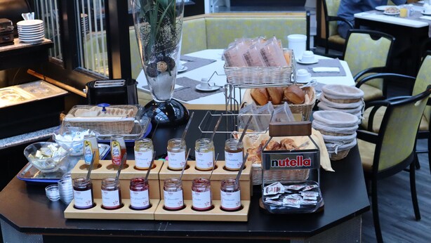 A breakfast buffet with various spreads, including Nutella, bread, and pastries. - Hotel Avenue (Nuremberg)