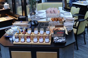 A breakfast buffet with various spreads, including Nutella, bread, and pastries. - Hotel Avenue (Nuremberg)