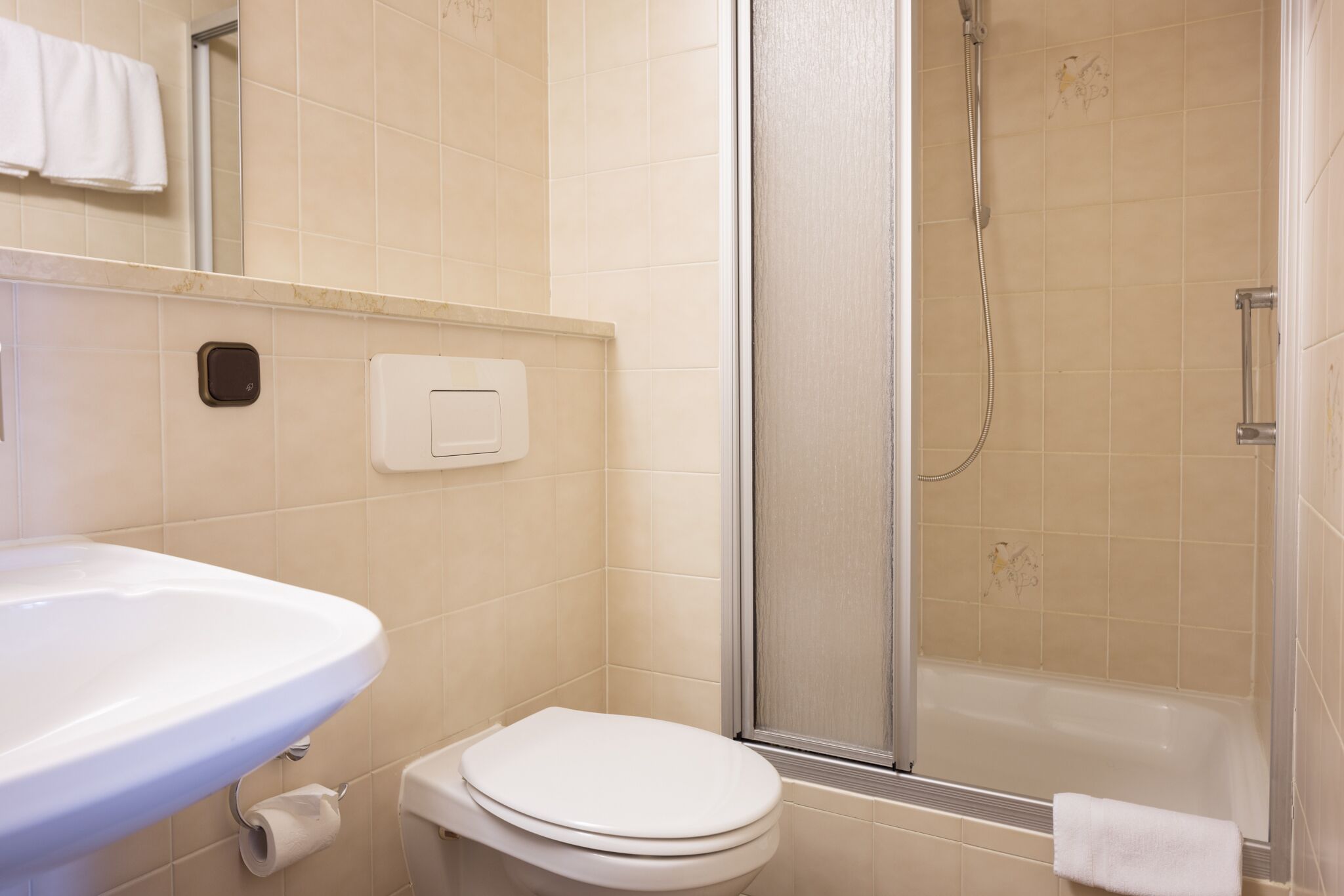 A bathroom with a sink, toilet, and shower area.