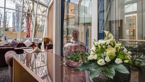 Un interior moderno con una mesa de vidrio, un florero decorativo y un arreglo floral.