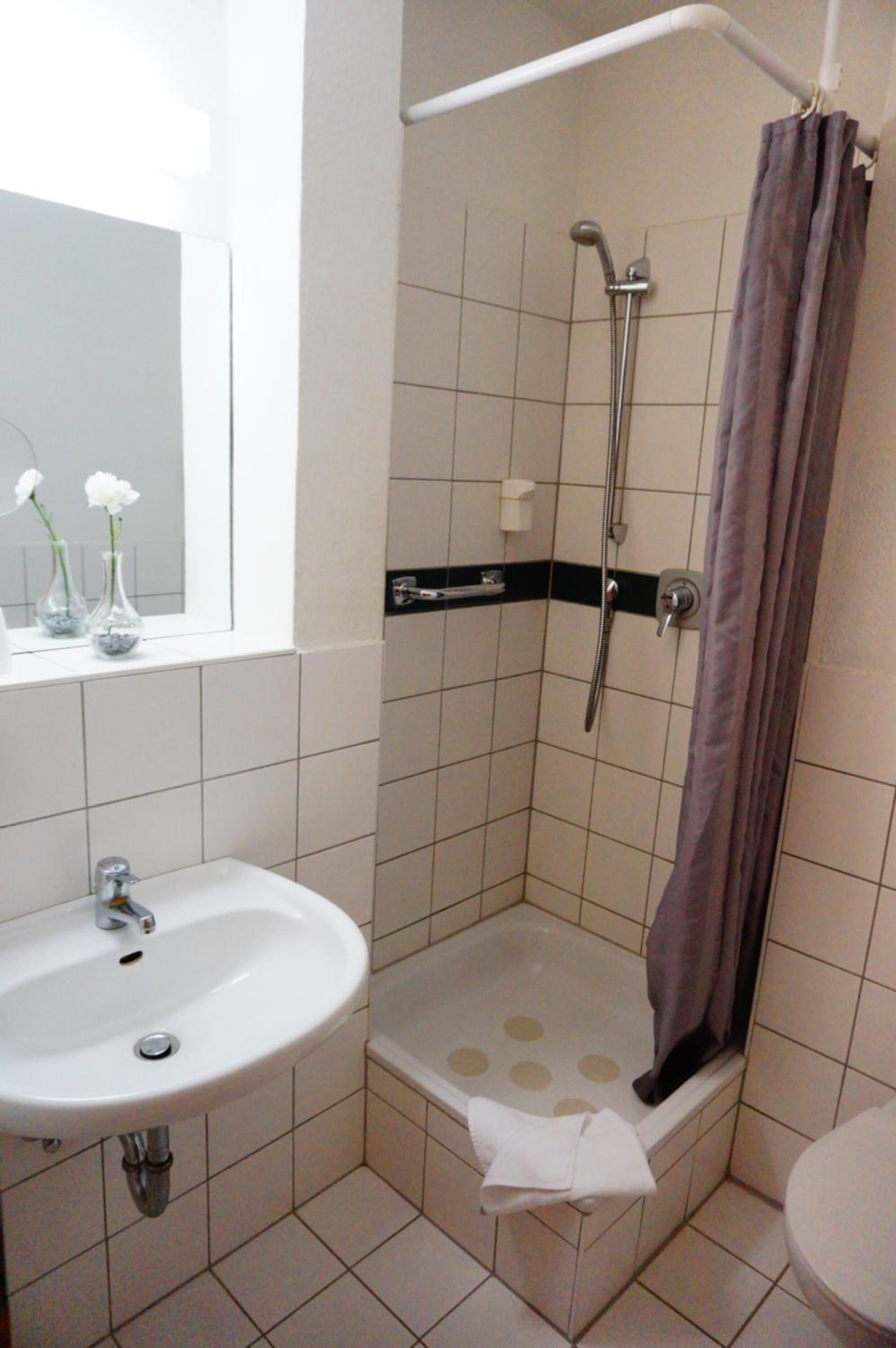Un baño con lavamanos, ducha e inodoro.