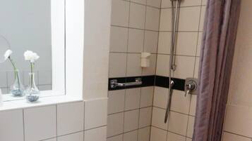 Un baño con lavamanos, ducha e inodoro.
