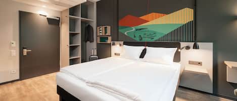 A modern hotel room with a large bed, built-in wardrobe, and a unique wall art piece.