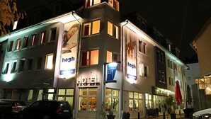 A hotel with a modern facade, multiple windows, and a prominent signage.