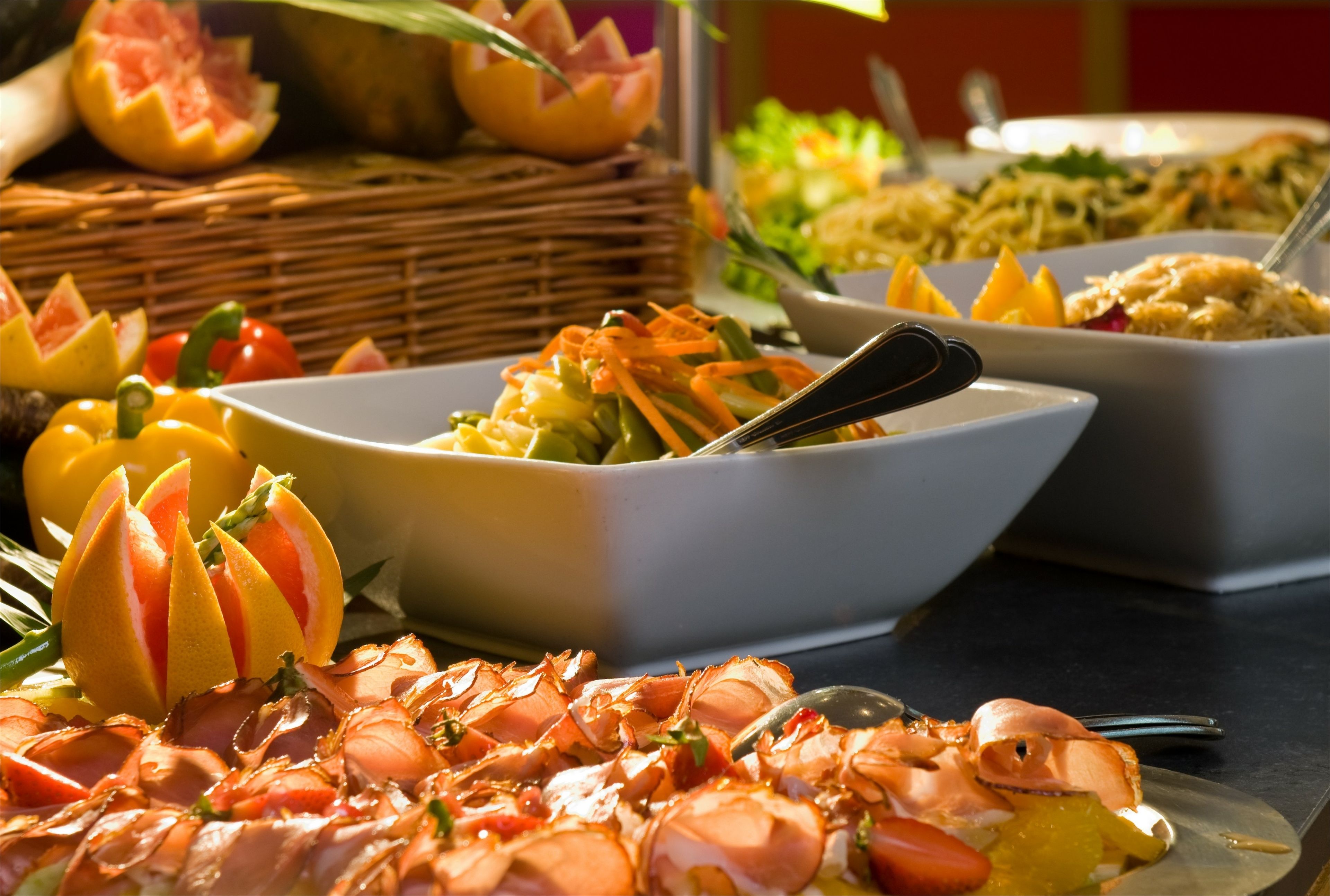 Una mesa de buffet con diversos platos, incluyendo mariscos, verduras y frutas.