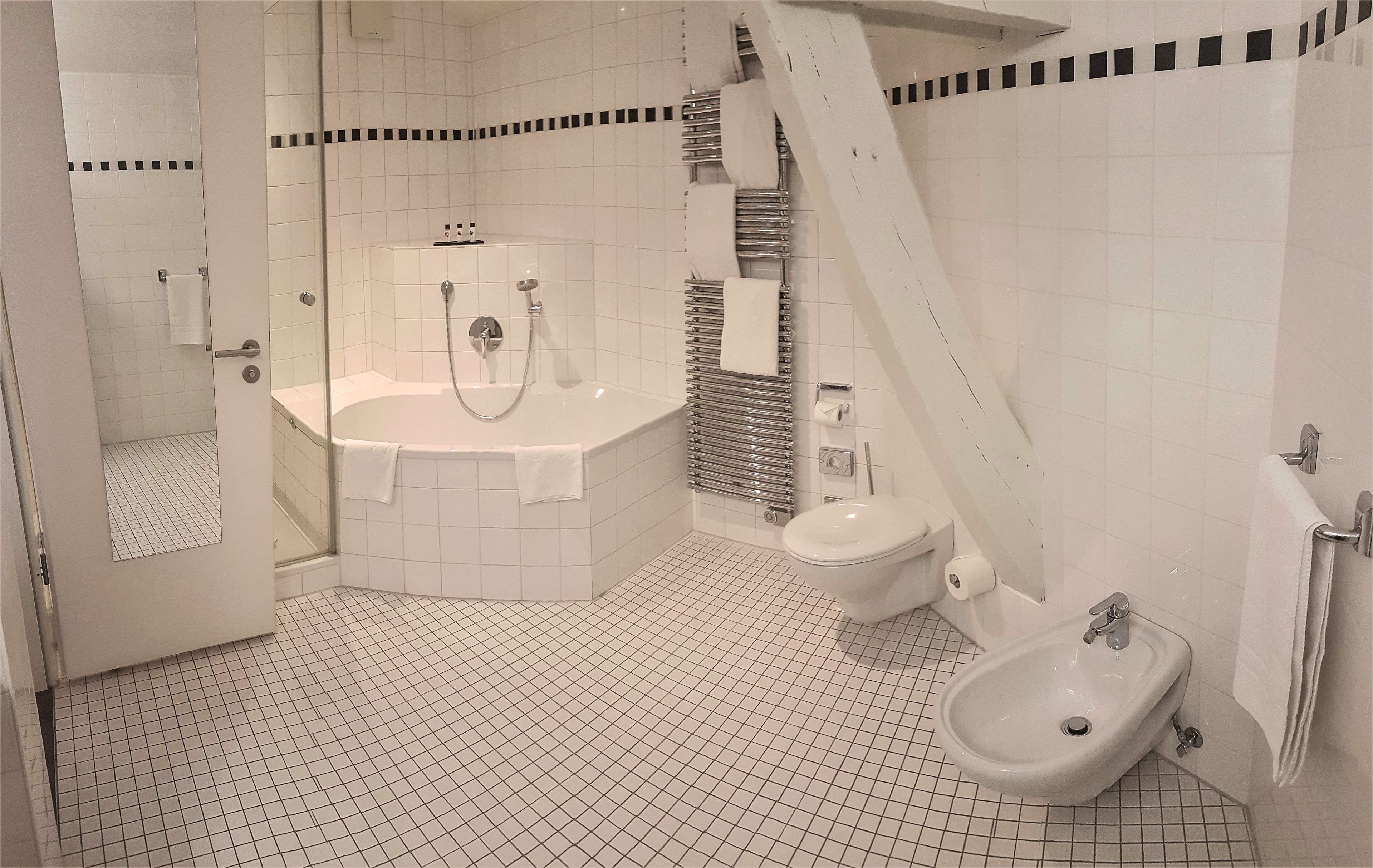 A modern bathroom with a bathtub, toilet, and sink.