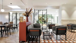 Ein modernes Interieur mit einer Sitzecke, Tischen und einer dekorativen Vase.