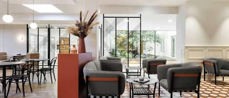 A modern interior with a seating area, tables, and a decorative vase.