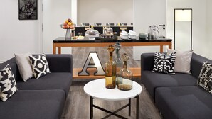 A modern living room with a sofa set, a coffee table, and a dining area with a buffet. - Classik Hotel Alexander Plaza (Berlin)