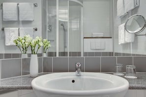 A modern bathroom with a white sink, a glass shower enclosure, and a mirror. - IntercityHotel Berlin Ostbahnhof (Berlin)