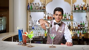 A bar setting with a bartender preparing drinks. - The Ambassador, Mumbai (Mumbai)
