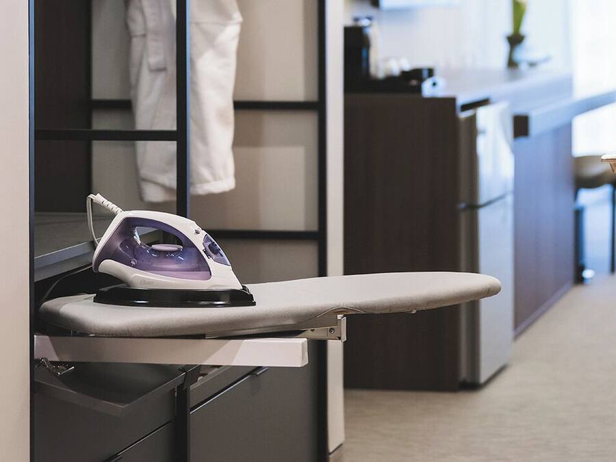 A modern kitchen with a built-in ironing station.