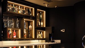 A bar area with shelves of bottles and a coffee machine. - Lidotel Caracas (Caracas)