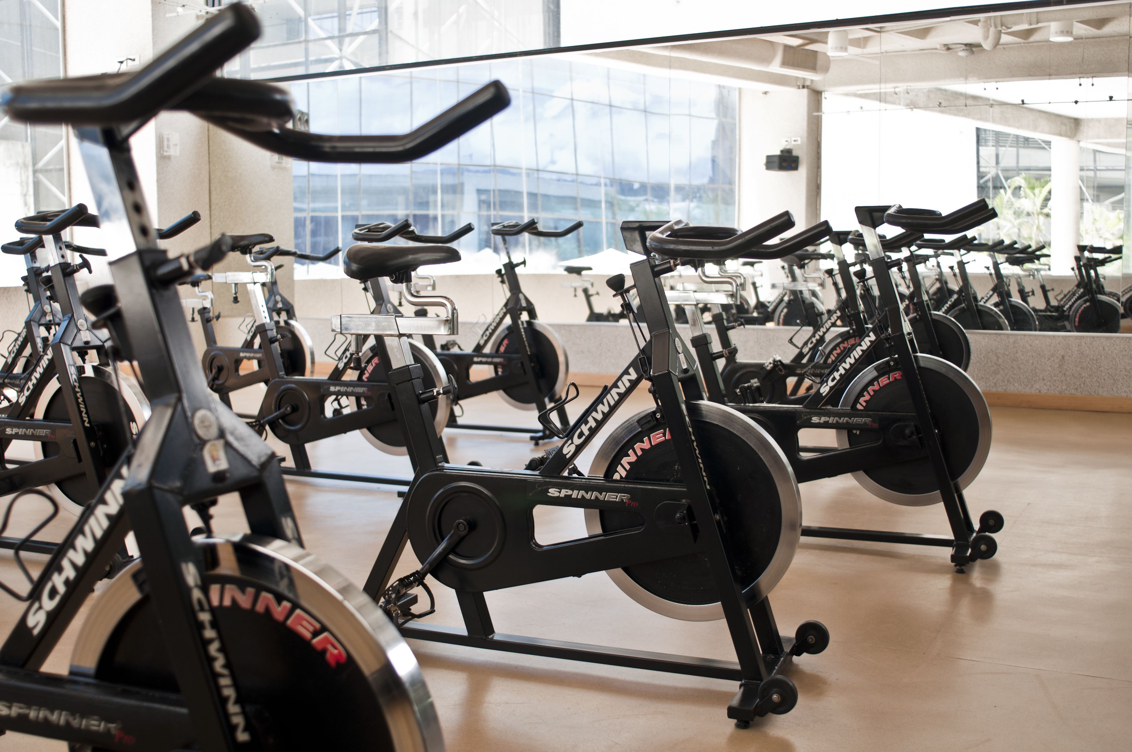 A gym with multiple stationary bikes labeled 'SCHWINNER' and 'SPINNER'.
