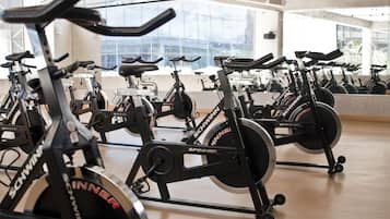 Une salle de sport équipée de plusieurs vélos d’appartement portant les marques « SCHWINNER » et « SPINNER ».