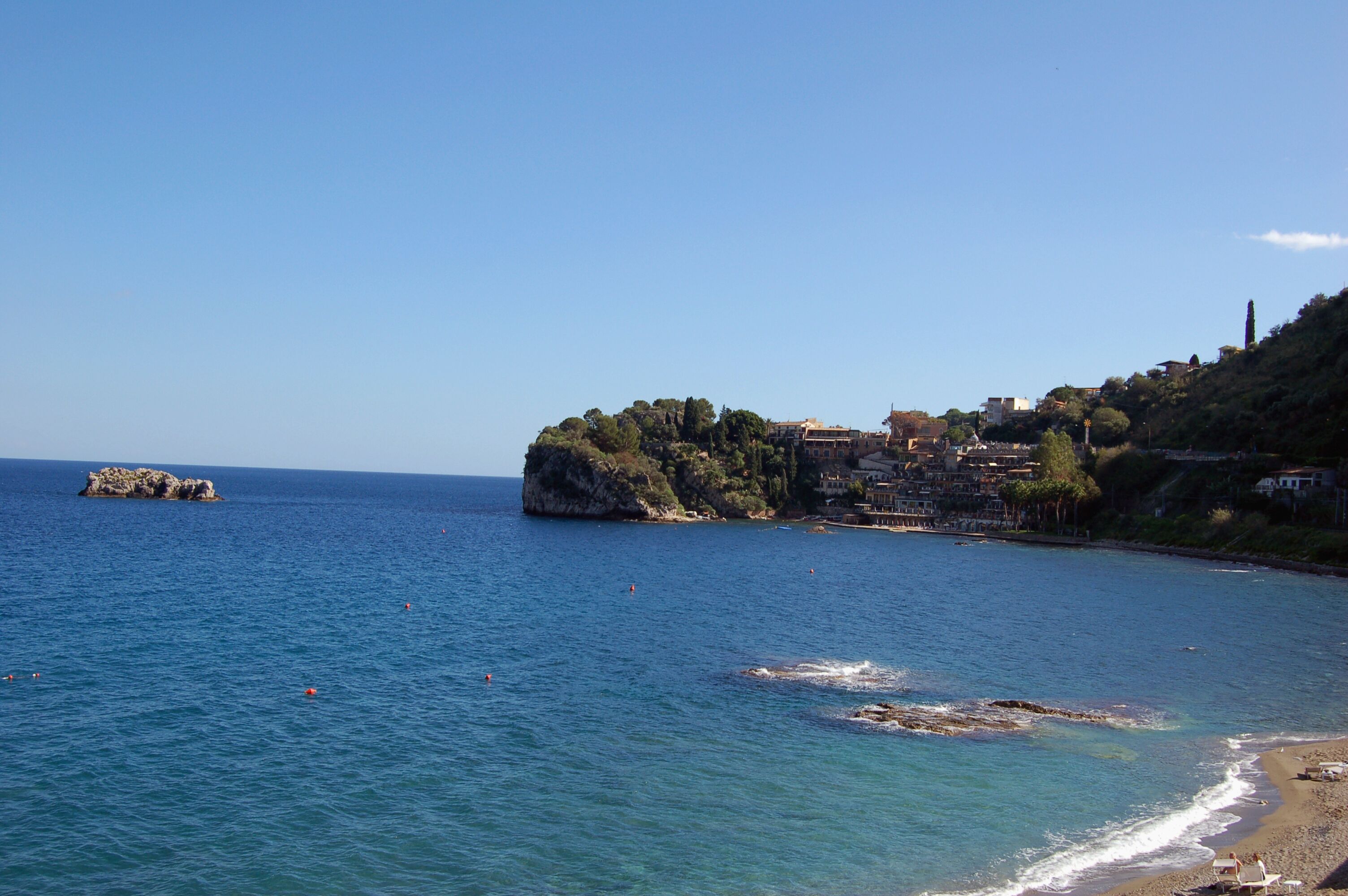 A coastal town with buildings on a hillside overlooking the sea.