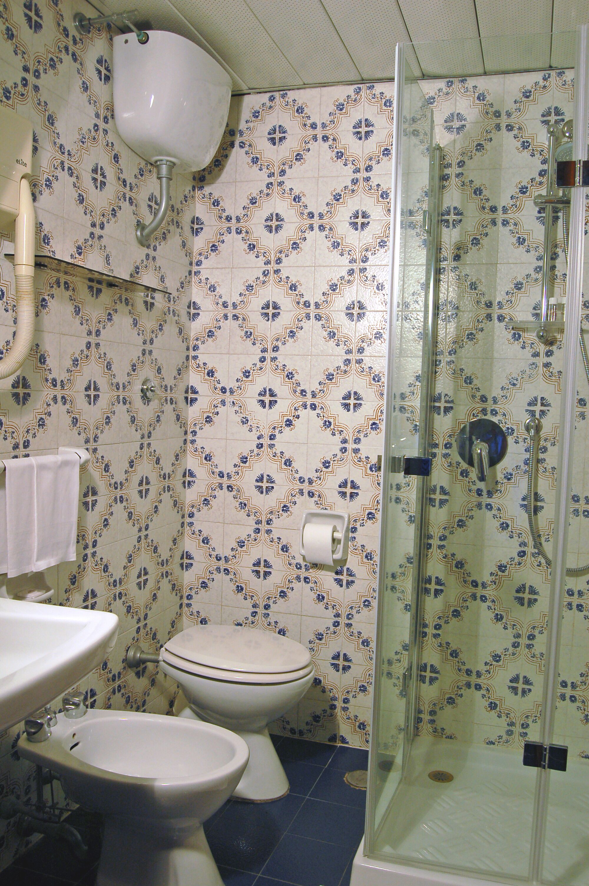 Casa de banho com sanita, bidé e cabine de duche.