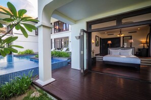 A hotel room with a large bed, a private balcony with a pool, and a view of the building's exterior. - Furama Resort Danang (Da Nang)