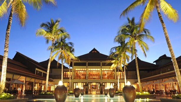A resort with a pool, palm trees, and a building with multiple floors and balconies. - Furama Resort Danang (Da Nang)