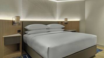 Ein modernes Hotelzimmer mit einem großen Bett, Nachttischen und Wandlampen.