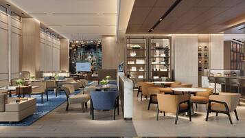 Un moderno vestíbulo de hotel con un amplio espacio de estar, un bar y una estantería bien organizada.