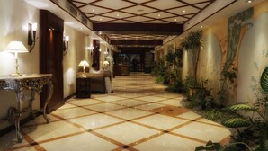 A hotel lobby with a checkered floor, ornate furniture, and wall art. - Safir International Hotel Kuwait (Kuwait City)