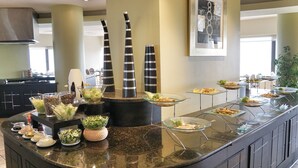 A buffet setup with various food items and condiments. - Safir International Hotel Kuwait (Kuwait City)