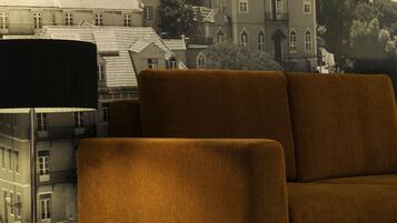 A modern living room with a sofa, a glass-top coffee table, and a lamp.